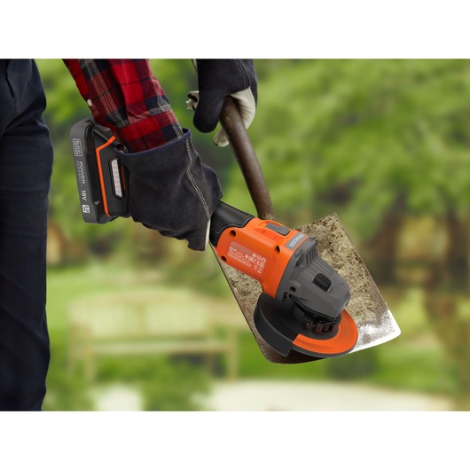Rust being removed from a spade with the BLACK+DECKER® 18V POWERCONNECT™ Brushless Angle Grinder.