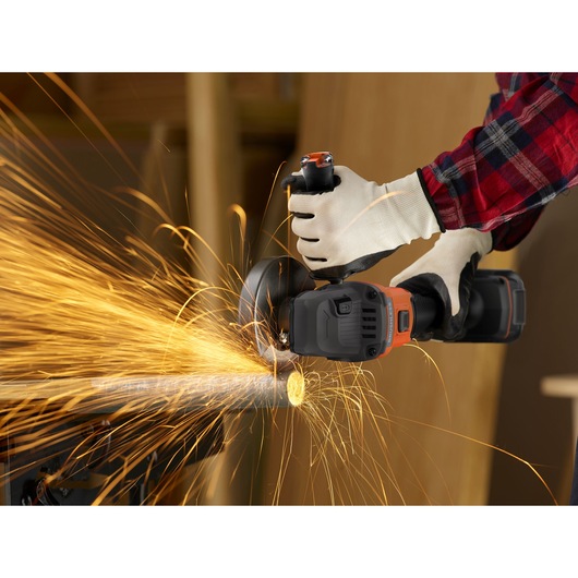 Photo of BLACKDECKER BCG6L8D1S cordless angle grinder cutting metal pipe, sparks flying, worker wearing gloves.