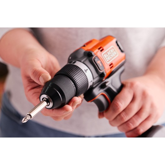 Photo of BLACKDECKER BLD683D1 cordless drill driver held in hands, with bit inserted, close-up view.